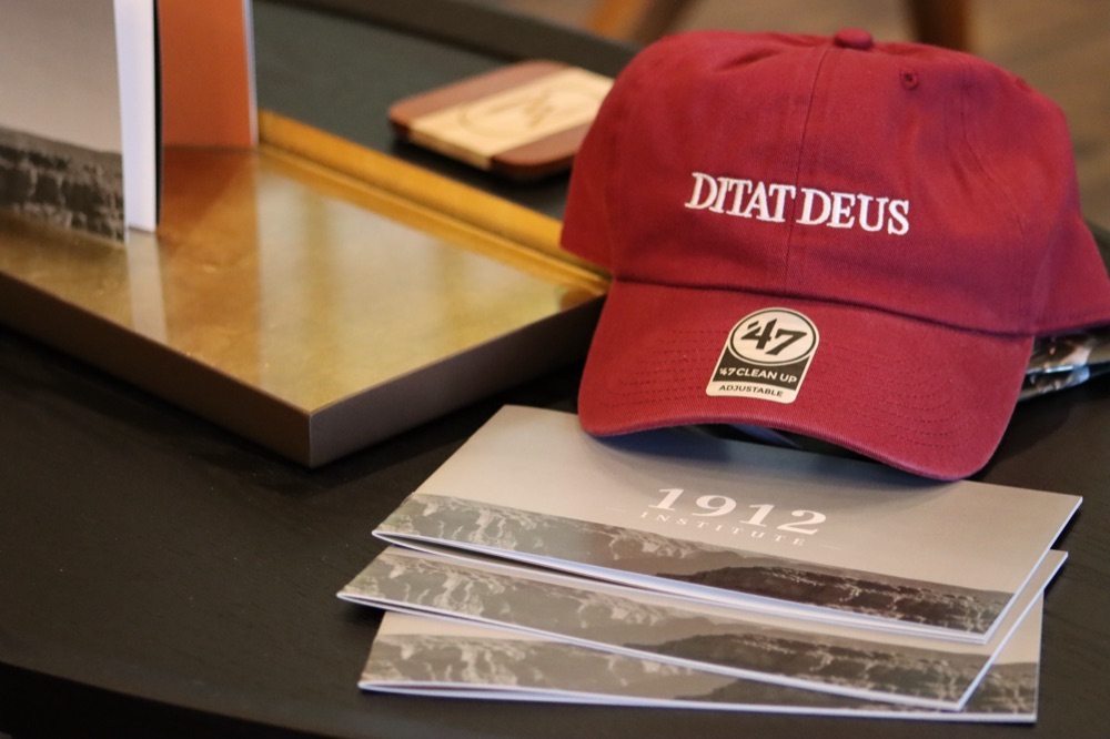 The Ditat Deus ball cap, cardinal red with the state motto embroidered in white